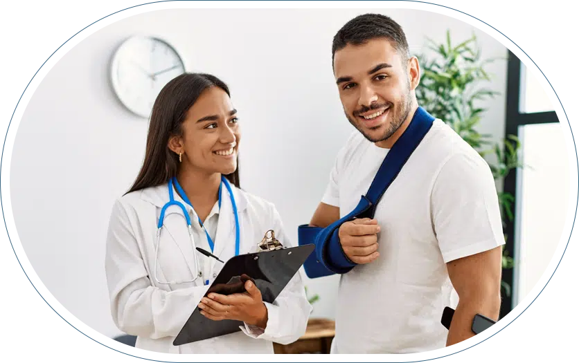 Young female doctor with a clipboard and pen smiling at her patient who is also smiling with a sling around his arm and shoulder after receiving orthopedic emergency care.