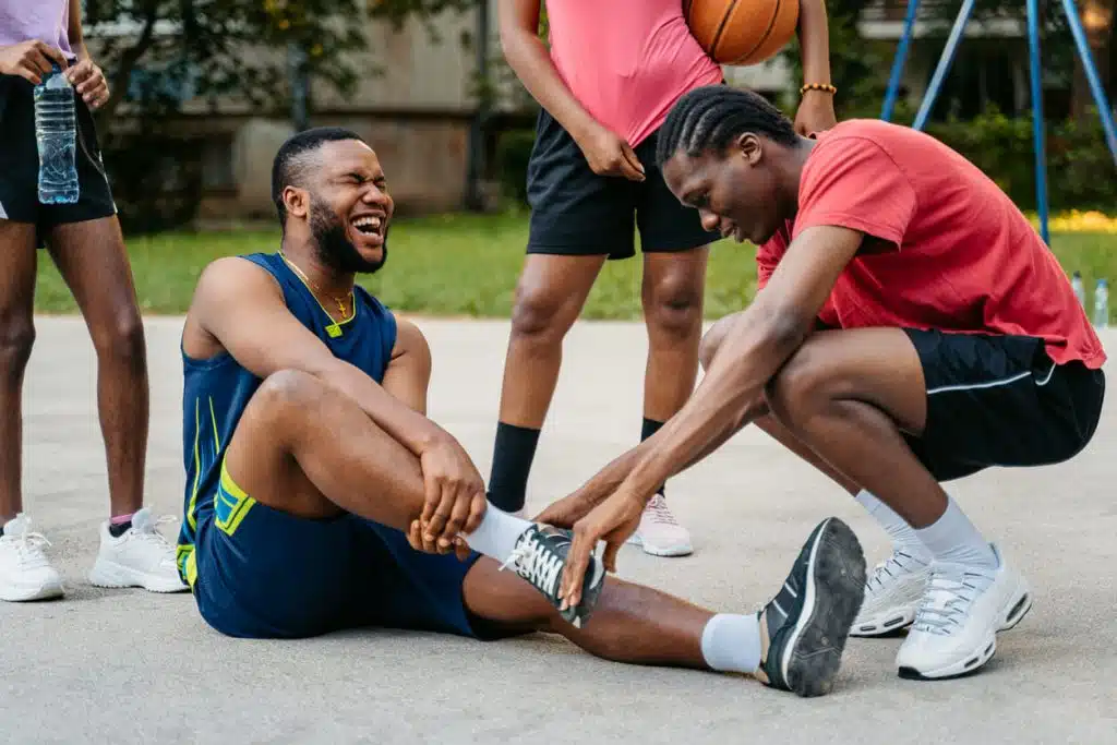 Young Man Injuring His Ankle While Playing Basketball