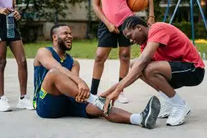 Young Man Injuring His Ankle While Playing Basketball