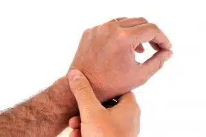 A man is holding his hand due to a condition that may be Dupuytren's contracture or trigger finger.