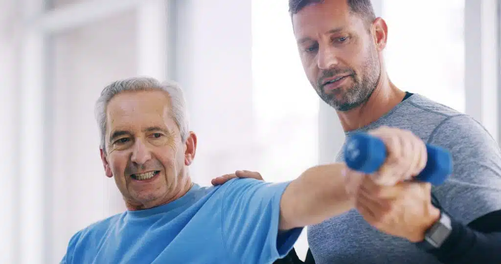 An elderly person is undergoing physiotherapy, while a man in an office is doing rehabilitation exercises for shoulder arthritis.
