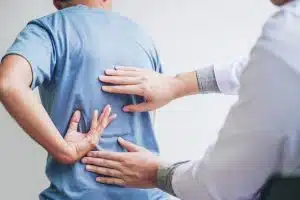 An orthopedic spine specialist is consulting with a patient regarding back pain issues and the potential need for physical therapy.