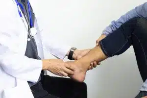 A foot and ankle orthopedic surgeon is checking the feet of a patient with diabetic foot problems.
