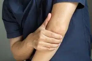 Man touching the elbow with tennis elbow pain And he relieves pain with massage.